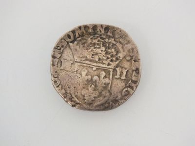 an old silver coin on a white surface with a white background