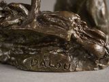 a bronze statue of a dog and a cat on a rock