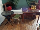 une petite table sur laquelle est posé un ours en peluche, dans un coin de la pièce
