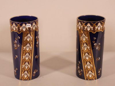 pair of blue and gold vases sitting on top of a white table