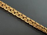a gold bracelet with a train on it on a table