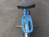 a small blue bike parked on the side of the road