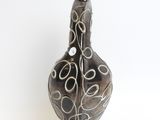 a black and white vase on a white surface