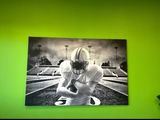 une photo en noir et blanc d'un footballeur devant un mur vert