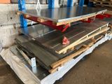 several pieces of metal are stacked on pallets in a warehouse