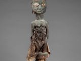 a wooden statue of a man with a hat on his head