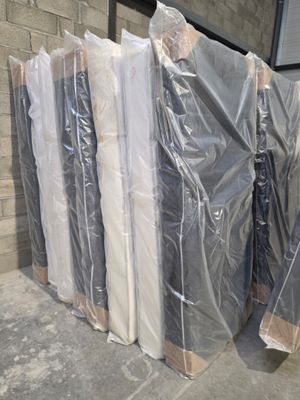 a lot of mattresses that are wrapped up and ready to be shipped