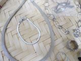 a lot of silver jewelry sitting on a table