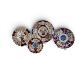 four different types of decorative plates are displayed on a white surface