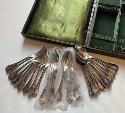 un lot de cuillères et fourchettes en argent dans une boîte