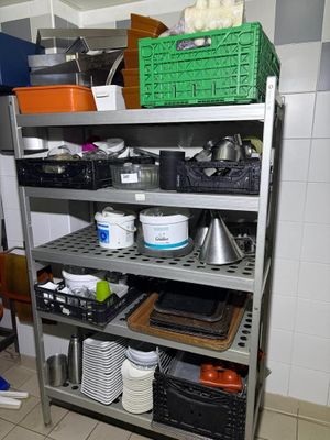 a metal shelf with various items on it in a kitchen