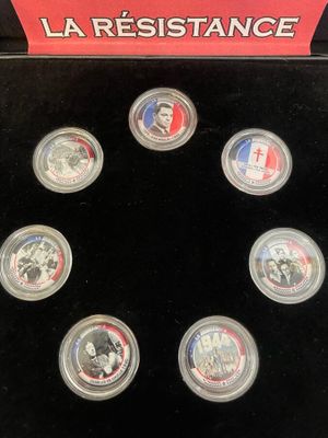 six commemorative coins in a display case with a red box