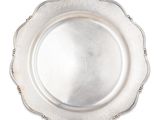 une assiette ancienne en argent au bord festonné sur fond blanc
