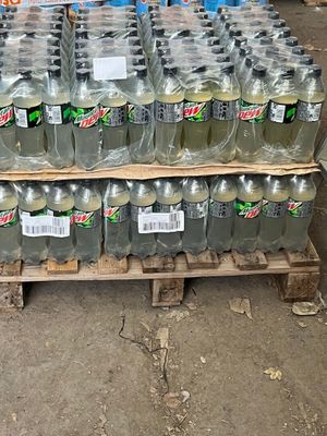 Des bouteilles de Mountain Dew sont empilées sur une palette dans un entrepôt