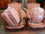 two pink chairs with bags on them in a room