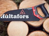 a black and red saw sitting on top of a pile of wood