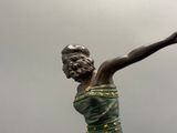 une statue représentant une femme tenant un frisbee à la main