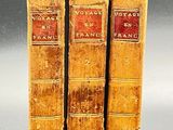 three old books are stacked on top of each other on a table