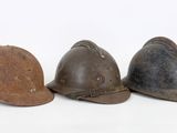 three helmets are lined up in a row on a white surface