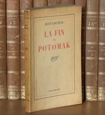 un livre posé sur une étagère, devant une pile de livres
