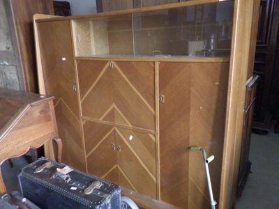 a wooden cabinet with a glass door and a suitcase in front of it