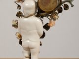 a statue of a baby holding a bunch of flowers on it ' s head