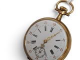 a gold pocket watch with roman numerals on it