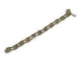 un gros plan d'un bracelet en métal sur fond blanc