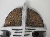 a white mask with a brown roof on a white wall