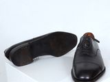 pair of men ' s black shoes sitting on top of a white box