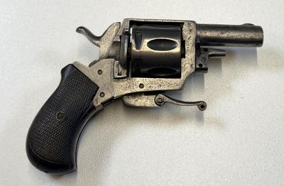 un petit pistolet posé sur une surface blanche