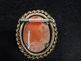 a close up of a ring with an orange stone in it