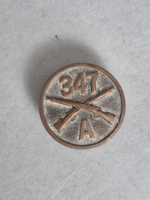 une image représentant un pin's en métal orné d'une batte de baseball et d'une balle