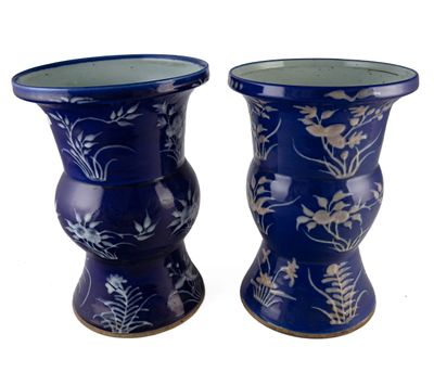 deux vases bleus ornés de fleurs sur fond blanc