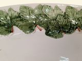 a white bowl with green leaves on the rim
