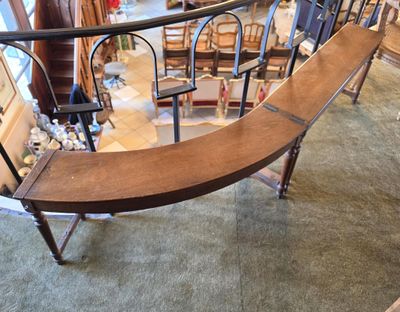 a curved wooden bench in the middle of a room