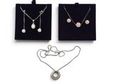deux colliers et une paire de boucles d'oreilles sur fond blanc