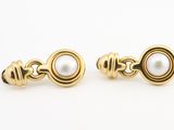 une paire de boucles d'oreilles en or et perles sur fond blanc