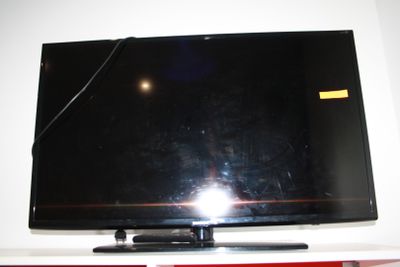 une télévision à écran plat posée sur une étagère blanche