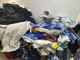 a pile of clothes sitting on the floor next to a wall