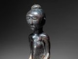 a close up of a statue of a person sitting on a table