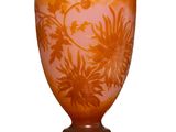 un vase orange orné d'un motif floral