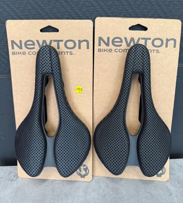 une paire de selles de vélo noires dans une boîte en carton