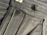 pantalon gris avec des fermetures éclair et un bouton sur le côté