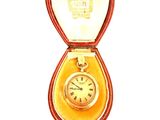 une montre en or dans un écrin rouge sur fond blanc