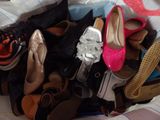many pairs of shoes that are sitting on a bed
