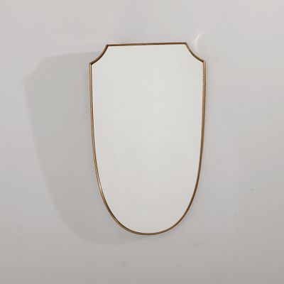 un miroir à cadre doré accroché à un mur blanc