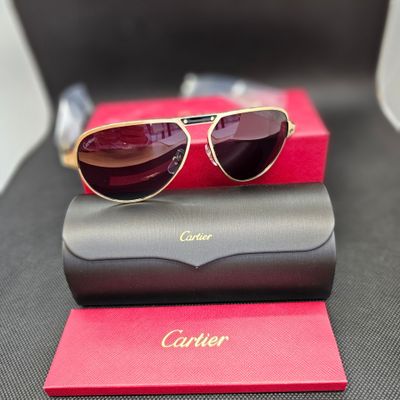 une paire de lunettes de soleil posée sur une boîte rouge, à côté d'une paire de lunettes