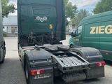 a green truck that is parked next to a green van