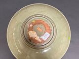 a green bowl with a brown design on the inside of it